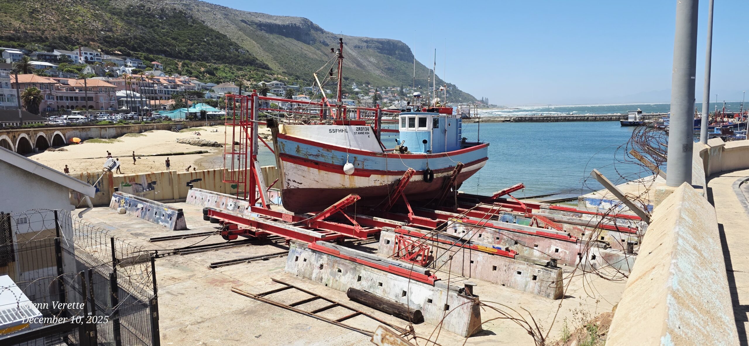 Fishing boat on red dry dock by coastline